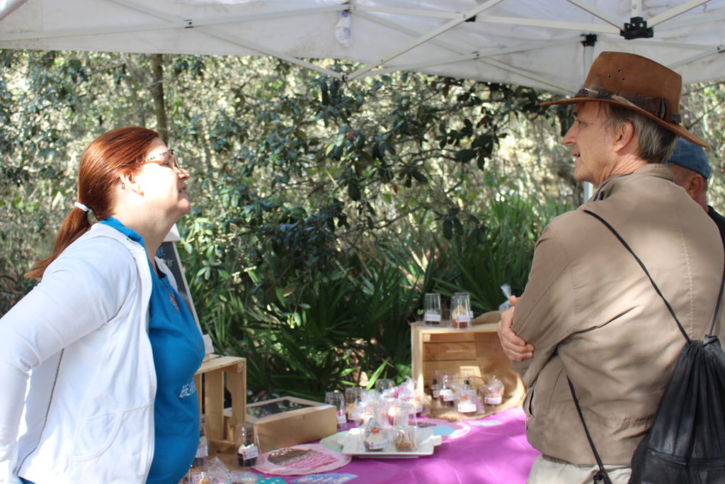 Two Garden Celebration attendees talk in front of a cupcake booth.